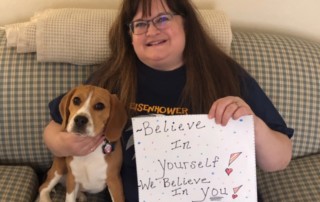 School nurse with sign that reads, "Believe in yourself. We believe in you!"